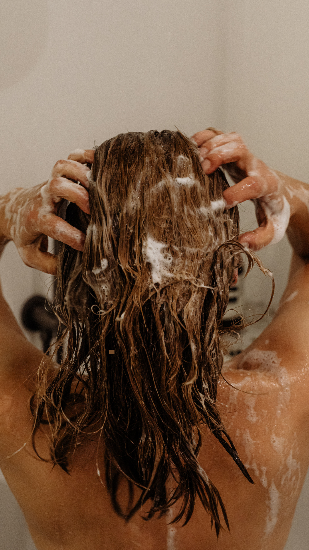 Girl washing her hair at home using clean, natural products